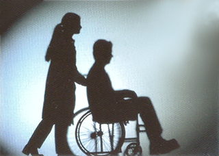 Silhouette of wheelchair user and carer